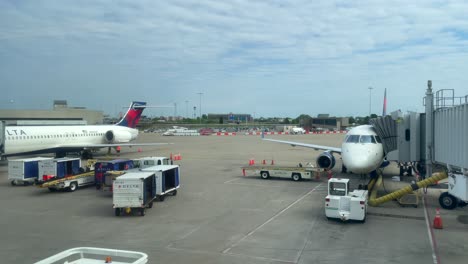 Pan-Right-of-Two-Delta-Planes-Being-Boarded-and-Loaded-at-SDF-International-Airport-in-Louisville,-Kentucky,-on-a-Cloudy-Afternoon