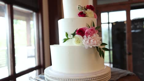 Triple-Tiered-Wedding-Cake-with-Beautiful-Flowers-and-White-Frosting,-Close-up