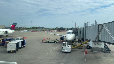 Panorámica-A-La-Derecha-De-Dos-Aviones-Delta-Siendo-Abordados-Y-Cargados-En-El-Aeropuerto-Internacional-SDF-En-Louisville,-Kentucky,-En-Una-Tarde-Nublada.