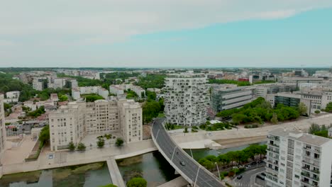 Aerial-orbiting-shot-around-the-famous-Arbre-Blanc-apartment-with-the-Lez-river