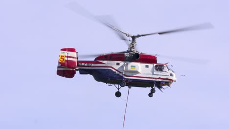 Ein-Kamov-Ka-32T-Feuerlöschhubschrauber-Fliegt-Davon,-Nachdem-Er-Den-Wassereimer-Gefüllt-Hat