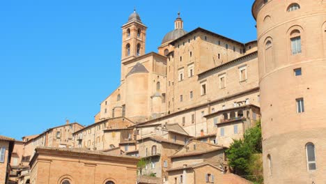 Low-angle-shot-of-Urbino-town-architecture-and-ducal-palace-in-Marche-region,-Urbino,-Italy-on-a-sunny-day