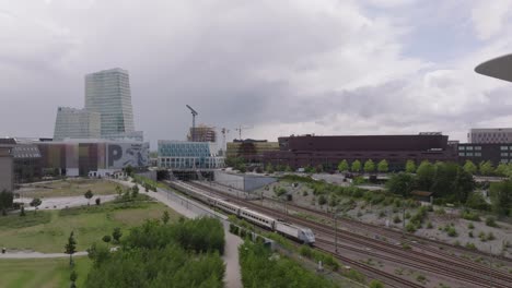 Trains-Leaving-And-Arriving-At-Hyllie-Railway-Station-With-Malmo-Arena-And-Water-Tower-In-Hyllie,-Malmo,-Sweden