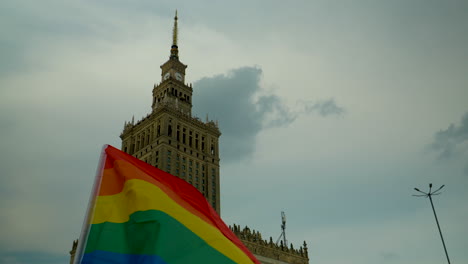 Colorida-Bandera-Lgbt-Ondeando-Con-El-Telón-De-Fondo-Del-Palacio-De-La-Cultura-Y-La-Ciencia-En-Varsovia-En-La-Plaza-Principal-Del-Centro-De-La-Capital