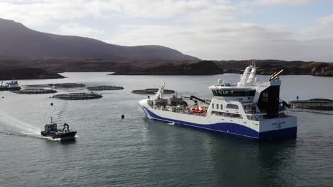 Drone-shot-of-a-fishing-boat-driving-past-a-Hebridean-fish-farming-vessel