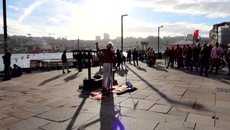 Typical-street-musician-scene-singing-and-playing-guitar-in-Porto,-Portugal