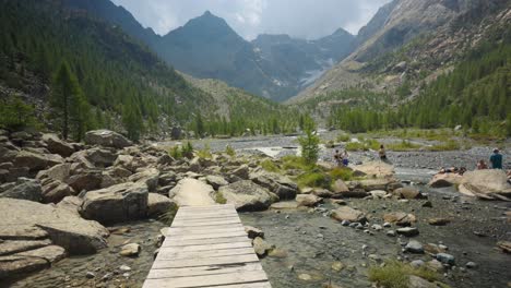 A-Woman-With-Backpack-Walking-On-Wooden-Jetty-On-The-Rocky-River
