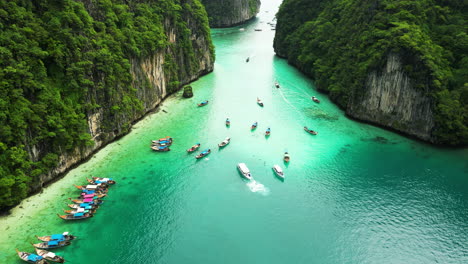 Aerial-flyover-shot-of-green-bay-with-tourist-boats-in-paradise-of-Thailand-during-sunny-day