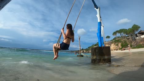 Tourist-Woman-Swinging-On-The-Beach-Of-Bali,-Indonesia---slow-motion