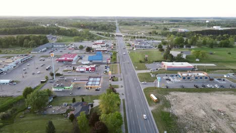 Small-town-of-Clare-in-Michigan,-USA,-and-the-M115-highway-in-background,-aerial-view