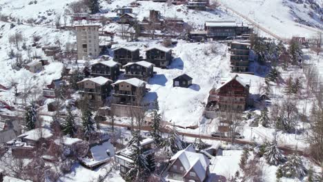 Aerial-view-circling-snow-covered-Farellones-hillside-village-ski-resort-chalet-and-hotel-neighbourhood-in-Santiago,-Chile