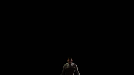 A-man-in-white-doing-acrobatics-on-a-black-background-in-slow-motion