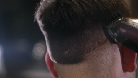 Close-up-view-on-male's-hairstyling-in-a-barber-shop-with-professional-trimmer.-Man's-haircutting-at-hair-salon-with-electric-clipper.-Grooming-the-hair.