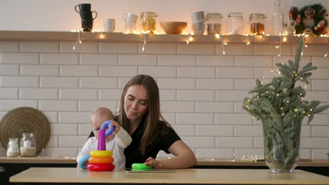 Toddler-with-mom-playing-with-the-toy-in-nursery-room.-Mother-with-her-1-year-old-baby-boy-having-fun-at-home