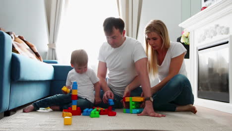 Glückliche-Familie,-Vater,-Mutter-Und-Baby-2-Jahre,-Die-In-Ihrem-Hellen-Wohnzimmer-Lego-Spielen.-Zeitlupenaufnahmen-Einer-Glücklichen-Familie