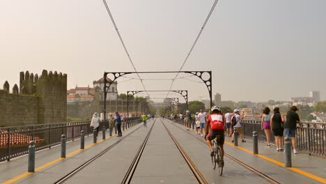 Scene-Of-Pedestrians-Walking-Over-Dom-Luís-I-Bridge-With-Tracks-In-Porto,-Portugal