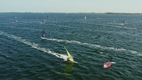 Tourists-Windsurfing-On-The-Scenic-Ocean-Of-Brouwersdam-Beach-In-The-Netherlands---aerial-drone-shot