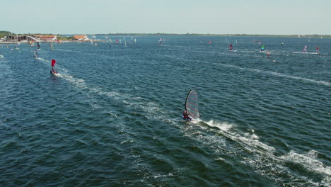 Vista-Aérea-De-Personas-Practicando-Windsurf-En-El-Mar-En-Ouddorp,-Países-Bajos---Disparo-De-Drones