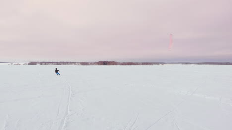 Kitesurfen-Im-Winter-Auf-Snowboard-Oder-Ski.-Schlittschuhlaufen-Auf-Dem-Eis-Im-Wind.-Wunderschöne-Farbige-Segel.