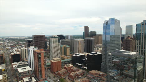 Aerial-Drone-Reversing-over-tall-buildings-and-skyscrapers-in-the-Downtown-area-of-Denver,-Colorado,-USA