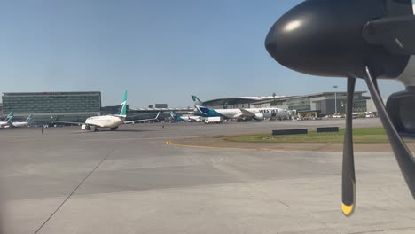 Airplane-Slowly-Driving-Through-Airport-Runway-Among-WestJet-Airplanes-at-Calgary-YYC-Airport-on-7-18-2023