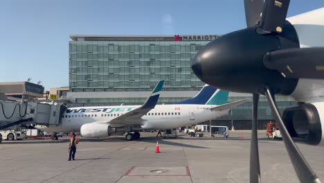 Estacionamiento-De-Aviones-De-Westjet-En-La-Puerta-Del-Aeropuerto-Cerca-De-Otro-Avión-De-Westjet-Estacionado-En-El-Aeropuerto-De-Calgary-Yyc-El-18-De-Julio-De-2023