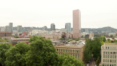 Toma-Aérea-Pasando-Por-El-Tanque-De-Agua-Del-Casco-Antiguo-Hacia-El-Centro-De-Portland,-Oregon