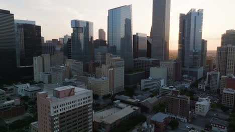 Drohnenschuss-Rückwärts-Fliegend-Von-Der-Innenstadt-Von-Houston,-Sonnenaufgang-In-Texas,-Vereinigte-Staaten