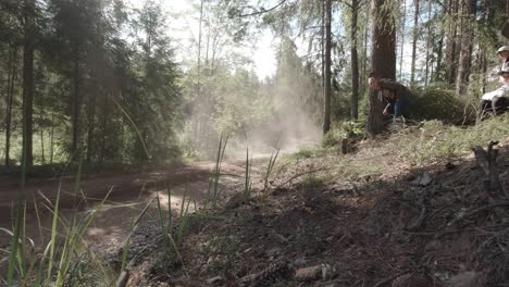 Rally-Wrc-En-Estonia,-El-Rápido-Coche-De-Rally-Vuela-A-Alta-Velocidad-En-Un-Camino-De-Grava-Rodeado-De-Bosque,-Se-Ve-Una-Nube-De-Polvo-A-La-Luz-Del-Sol