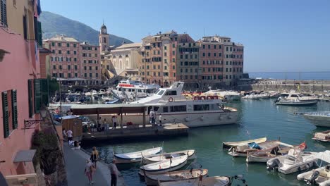 Boote,-Die-Im-Hafen-Von-Ligurien-Navigieren-Und-Anlegen,-Und-Malerische-Ausblicke-Auf-Bunte-Häuser-In-Camogli,-Italien