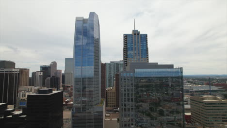 Drone-slow-rising-among-skyscrapers-in-the-city-of-Downtown-Denver-Colorado,-USA