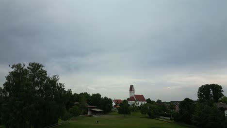 Hintergrund-Der-Blauen-Stunde-über-Einer-Kleinen-Deutschen-Stadtkirche,-Umgeben-Von-Bäumen