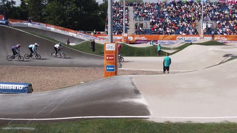 Female-BMX-riders-coming-off-a-wide-bend-on-the-course