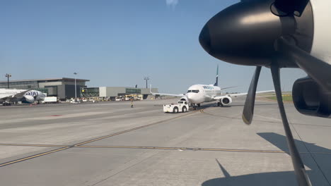 Airplane-Driving-Past-Parked-WestJet-Airplane-on-Airport-Runway-at-Calgary-YYC-Airport-on-7-18-2023