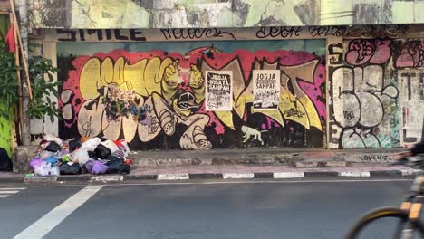 You-can-see-piles-of-rubbish-on-the-side-of-the-Mataram-road,-and-you-can-see-posters-that-say-"Jogja-Garbage-Tourism