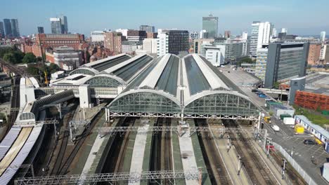 Aerial-drone-flight-over-Piccadilly-Train-Station-with-a-skyline-view-of-Manchester-City-Centre