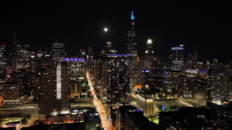 Aerial-view-following-the-Monroe-street-toward-West-Loop,-night-in-Chicago,-USA