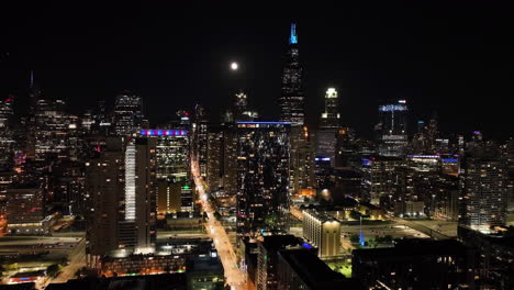 Vista-Aérea-Siguiendo-La-Calle-Monroe-Hacia-West-Loop,-Noche-En-Chicago,-Estados-Unidos