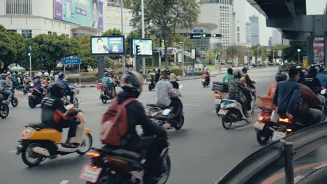Motorbikes-and-scooters-driving-through-the-streets-of-Bangkok,-Thailand-in-slow-motion