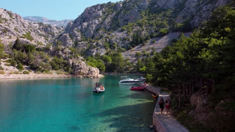 Eine-Atemberaubende-Drohnenansicht-Der-Zavratnica-Bucht-In-Kroatien-Mit-Ankernden-Booten,-Touristen-Und-Der-Atemberaubenden-Mittelmeerküste-An-Einem-Sonnigen-Sommertag