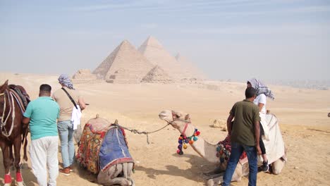 Touristen-Reiten-Und-Steigen-Aus-Kamelen-An-Den-Pyramiden-Von-Gizeh-In-Ägypten