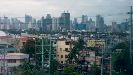 Urban-view-of-capital-city-Manila-in-the-Philippines-with-buildings,-skyscrapers-and-electricity-cables-on-a-grey,-overcast-day-during-wet-season