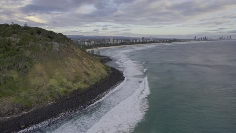 Rolling-Waves-Onto-Burleigh-Heads-Beach-On-A-Cloudy-Day-In-Gold-Coast,-Australia---aerial-shot
