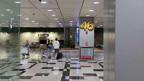 Travelers-Collecting-Their-Luggage-At-The-Baggage-Claim-Area-Of-Singapore-Changi-Airport-Terminal-3