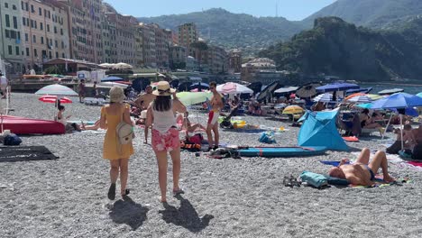 Scene-of-tourists-soaking-in-the-warm-Mediterranean-sun-along-the-famous-Camogli-Beach,-Italy