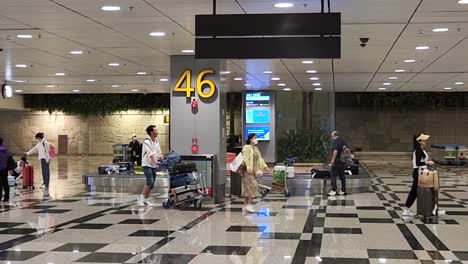 Passengers-Claiming-Their-Luggage-At-The-Baggage-Claim-Conveyor-In-Singapore-Changi-Airport