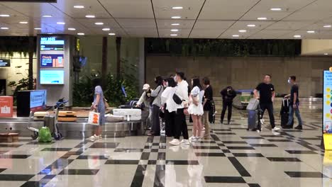 Touristen-Warten-Darauf,-Ihr-Gepäck-Auf-Dem-Förderband-Am-Terminal-3-Des-Flughafens-Singapur-Changi-Abzuholen