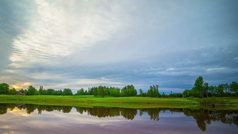 A-timelapse-of-a-pond-with-a-grassy-edge-and-clouds-passing-overhead