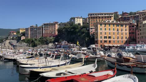 Captivating-views-of-boats-mooring-side-by-side-in-the-port-of-Liguria-and-picturesque-views-of-colourful-houses-in-Camogli,-Italy