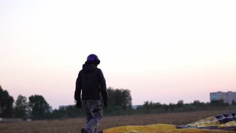 Parachutist-decomposes-the-parachute-before-the-flight,-so-as-not-to-confuse-the-slings.-Preparation-of-flight-paraglider-parachute